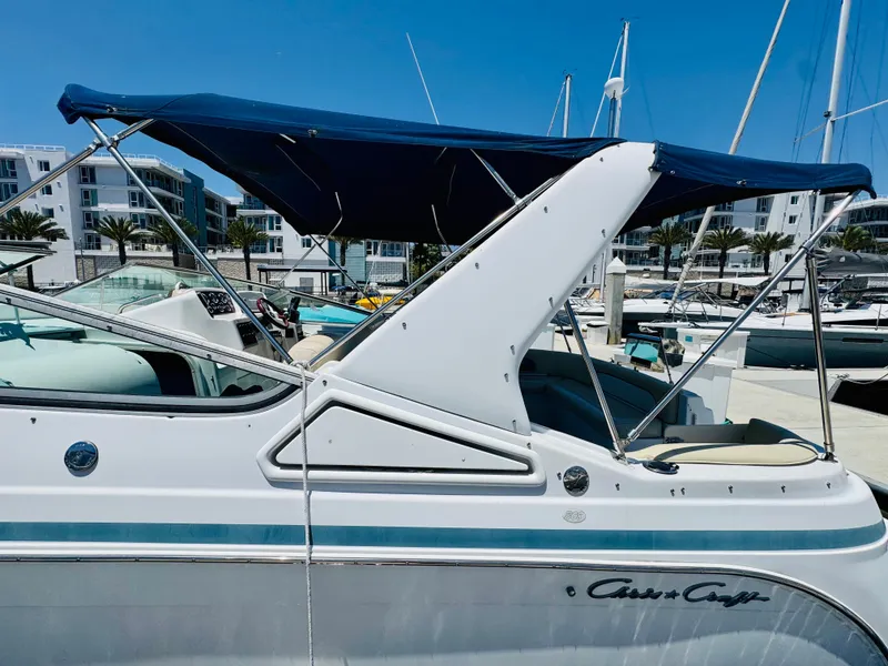 Slide: The Image of 2000 Chris-Craft 308 Express Cruiser docked, featuring a blue canopy and sleek design. - 17