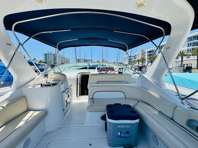 Slide: The Image of 2000 Chris-Craft 308 Express Cruiser interior with seating, canopy, and cooler at marina. - 18