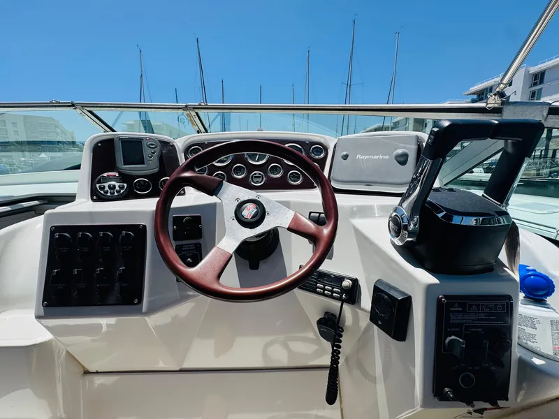 Slide: The Image of 2000 Chris-Craft 308 Express Cruiser helm with steering wheel and navigation controls. - 22