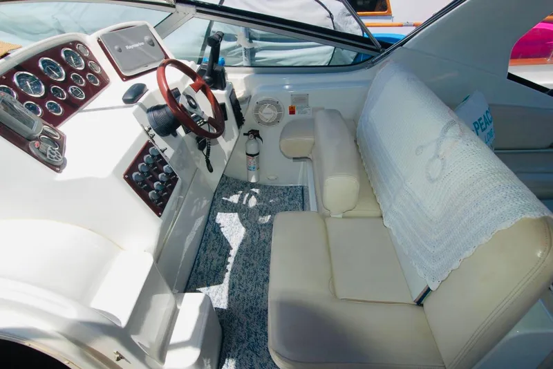 Slide: The Image of 2000 Chris-Craft 308 Express Cruiser cockpit with steering wheel and seating area. - 23