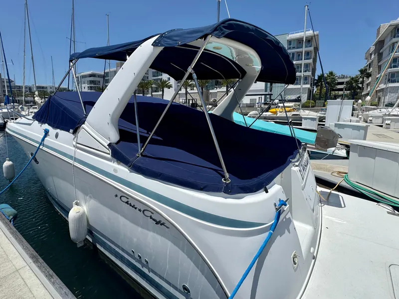 Slide: The Image of 2000 Chris-Craft 308 Express Cruiser docked at a marina under clear blue skies. - 3