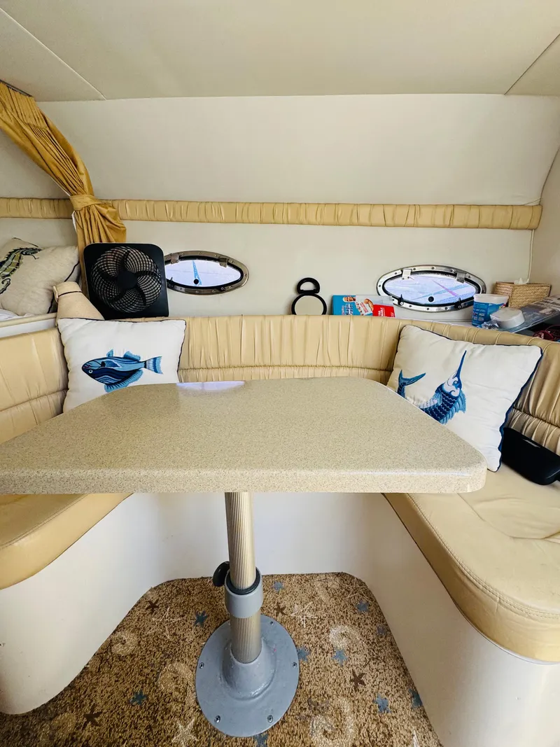 Slide: The Image of 2000 Chris-Craft 308 Express Cruiser interior with beige seating and fish-themed pillows. - 32