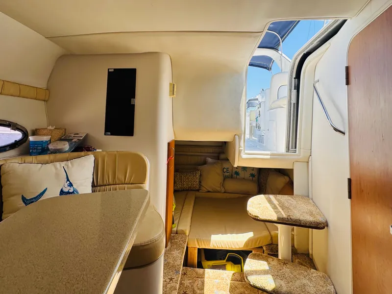 Slide: The Image of Interior of 2000 Chris-Craft 308 Express Cruiser, featuring cozy seating and a compact dining area. - 34