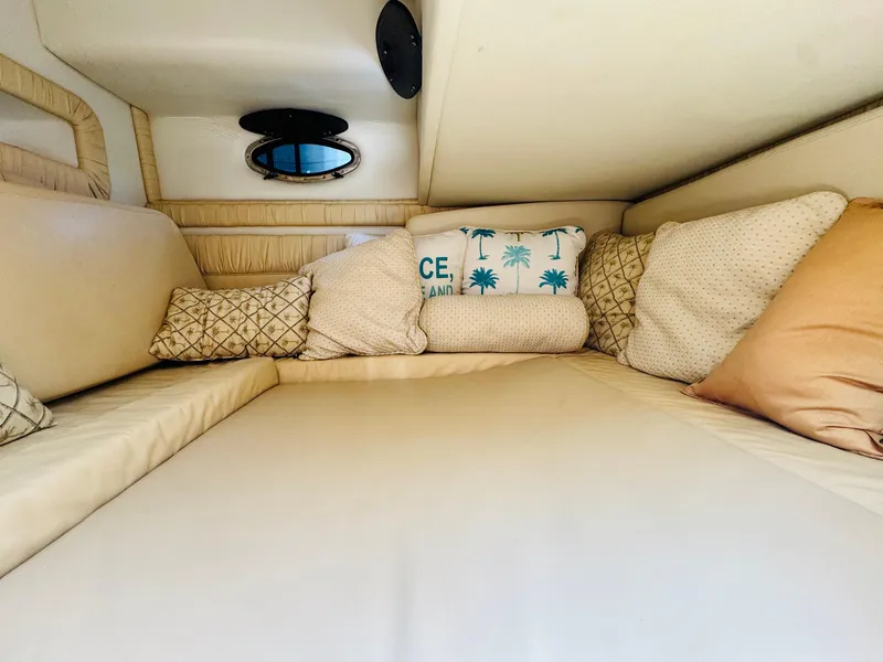 Slide: The Image of Cozy cabin interior of 2000 Chris-Craft 308 Express Cruiser with plush cushions and porthole. - 47