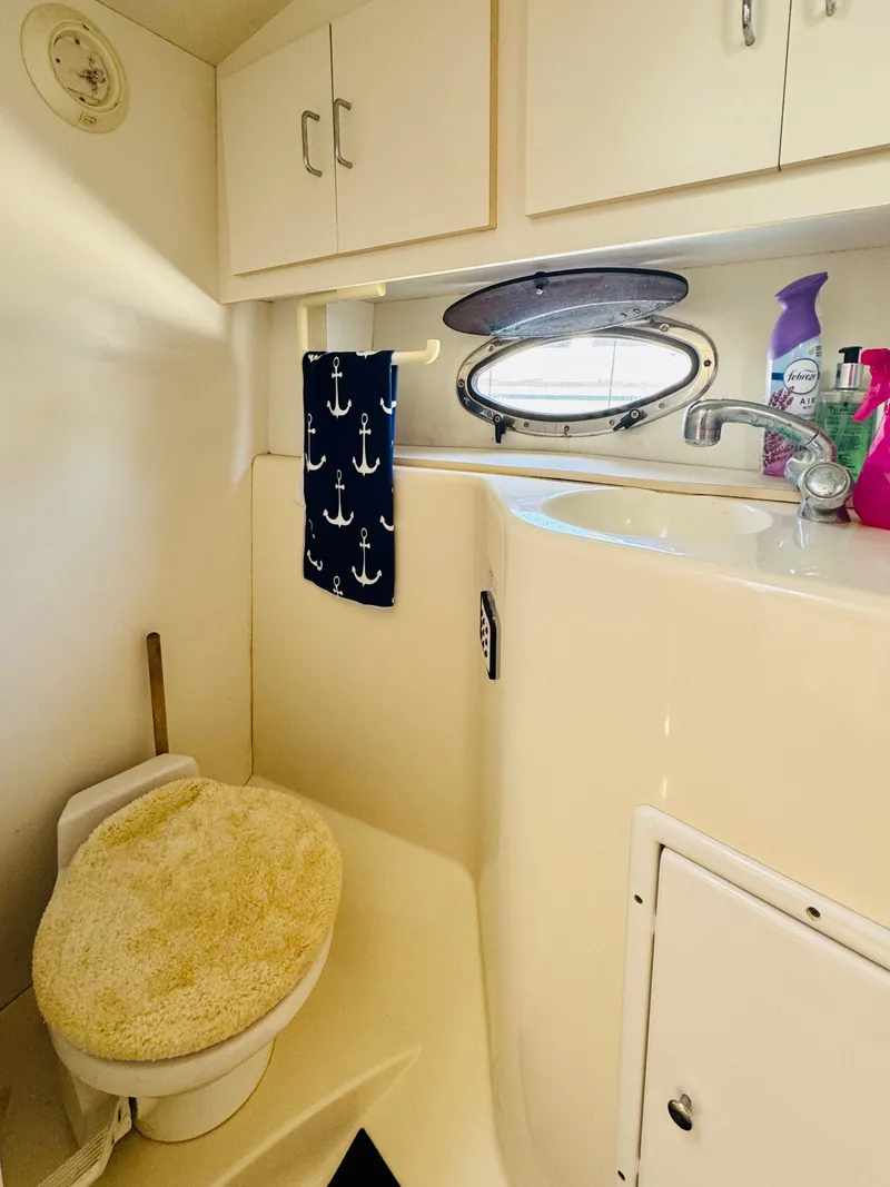 Slide: The Image of 2000 Chris-Craft 308 Express Cruiser bathroom with porthole and anchor-themed decor. - 48