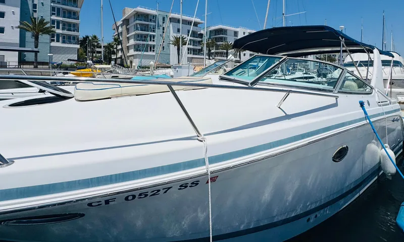 Slide: The Image of 2000 Chris-Craft 308 Express Cruiser docked at marina with modern buildings in background. - 8