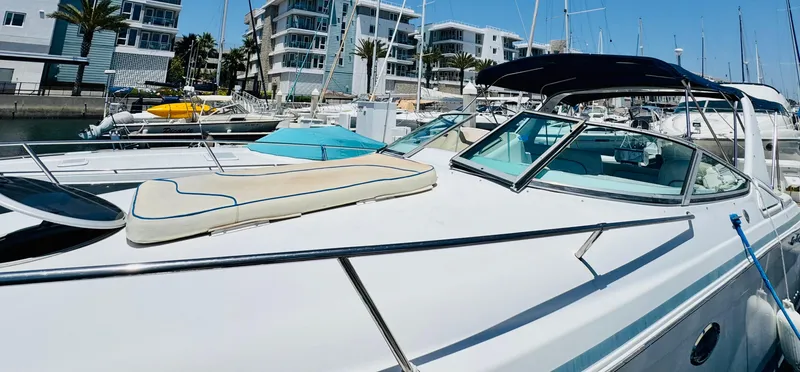 Slide: The Image of 2000 Chris-Craft 308 Express Cruiser docked at marina with modern buildings in background. - 9