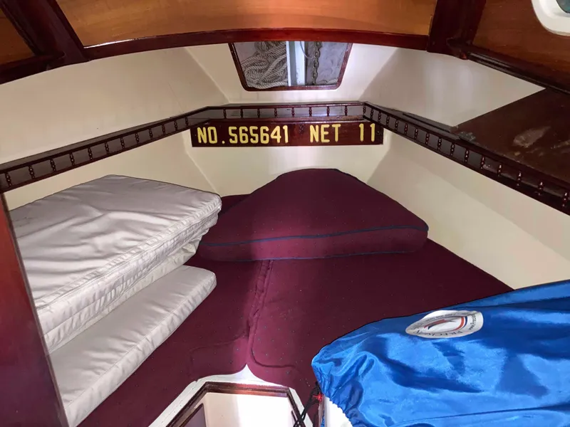 Slide: The Image of 1974 Cheoy Lee Clipper Ketch cabin interior with bedding and storage. - 11