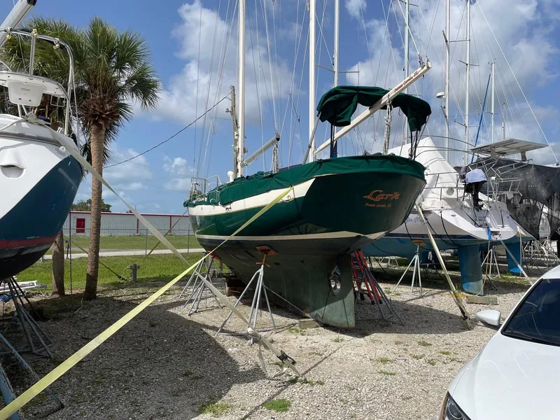 Slide: The Image of 1974 Cheoy Lee Clipper Ketch sailboat on stands in a boatyard under a blue sky. - 17