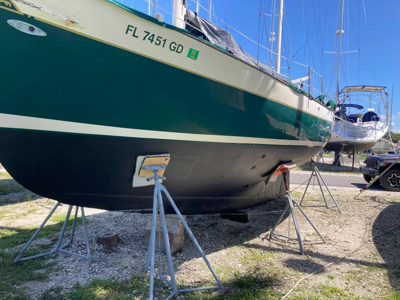 Slide: The Image of 1974 Cheoy Lee Clipper Ketch sailboat on stands, green hull, sunny day. - 19