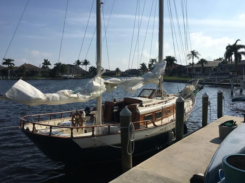 Slide: The Image of 1974 Cheoy Lee Clipper Ketch docked in a sunny marina setting. - 2