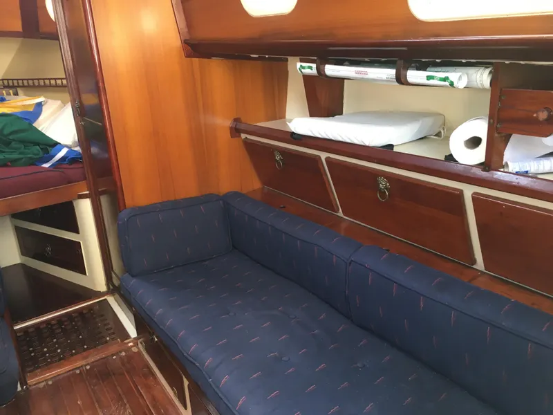 Slide: The Image of 1974 Cheoy Lee Clipper Ketch interior with blue sofa, wooden cabinets, and cozy sleeping area. - 5