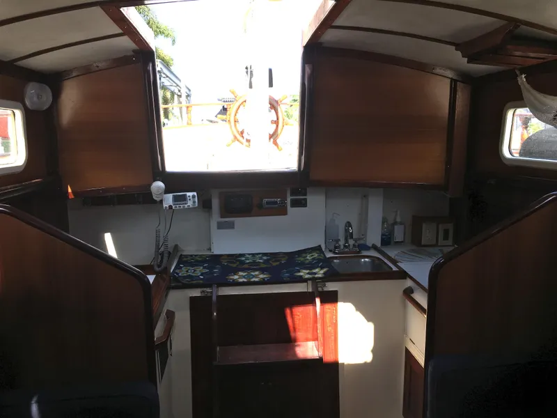 Slide: The Image of 1974 Cheoy Lee Clipper Ketch interior with wooden cabinetry and compact kitchen area. - 6