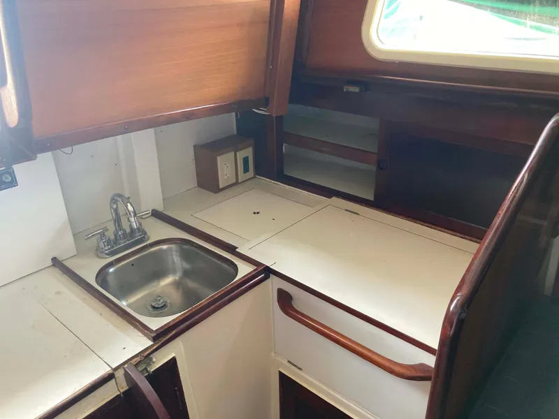 Slide: The Image of 1974 Cheoy Lee Clipper Ketch galley with sink, wooden cabinetry, and countertop. - 8