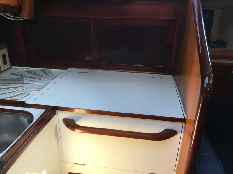 Slide: The Image of 1974 Cheoy Lee Clipper Ketch interior with wooden cabinetry and countertop. - 9
