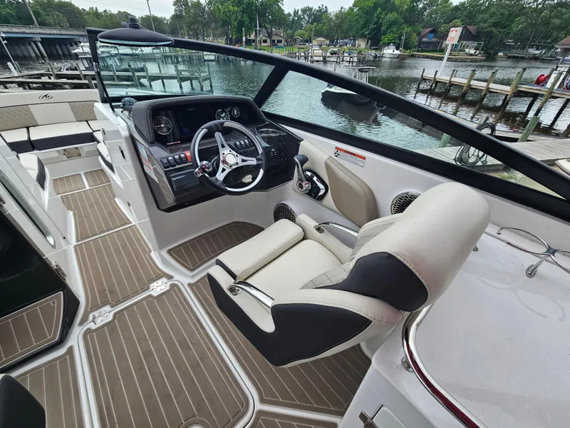 Slide: The Image of 2023 Monterey M-65 boat interior with sleek helm, modern controls, and comfortable seating. - 13