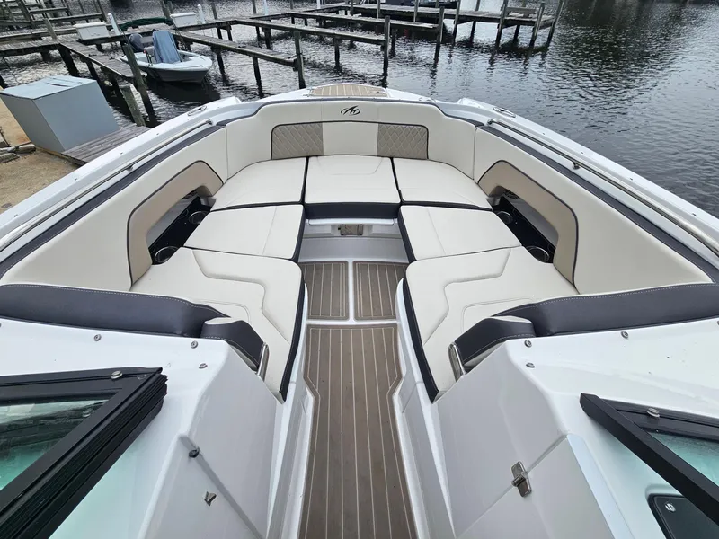Slide: The Image of 2023 Monterey M-65 boat with spacious seating, docked at a marina. - 18