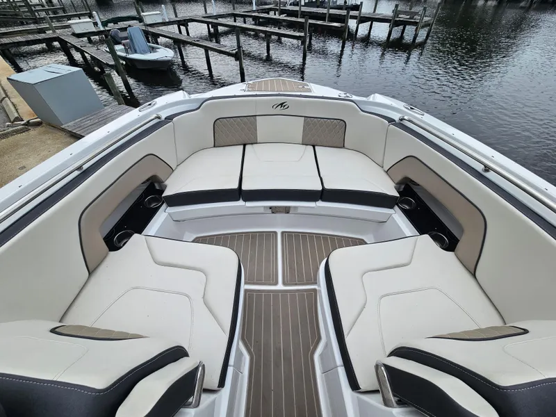 Slide: The Image of 2023 Monterey M-65 boat interior with luxurious seating and elegant design at a marina. - 19