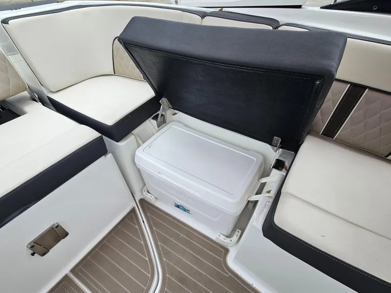 Slide: The Image of 2023 Monterey M-65 boat interior with open storage compartment and cushioned seating. - 20