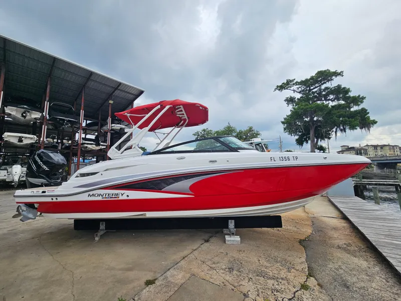 Slide: The Image of 2023 Monterey M-65 boat with red and white design, docked under cloudy skies. - 4