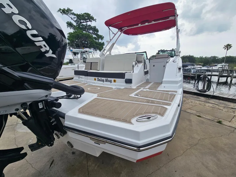 Slide: The Image of 2023 Monterey M-65 boat with red canopy, docked at marina, featuring Mercury engine. - 6