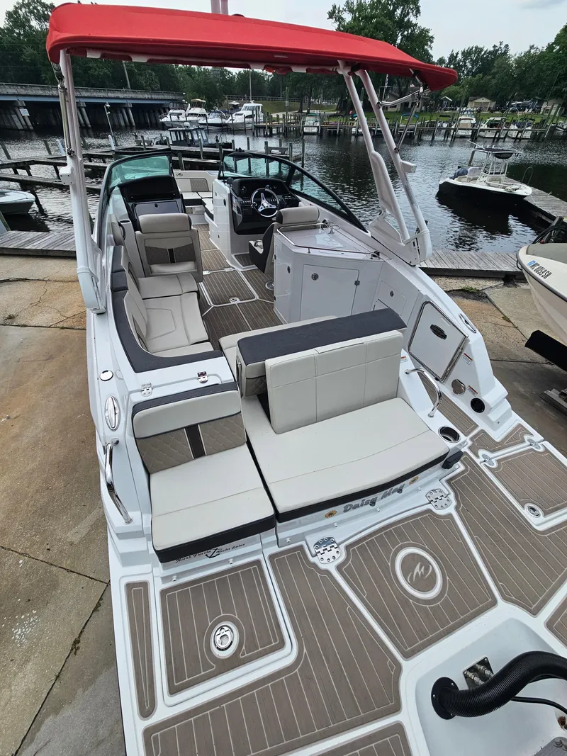 Slide: The Image of 2023 Monterey M-65 boat with red canopy, docked at marina, featuring spacious seating and modern design. - 7