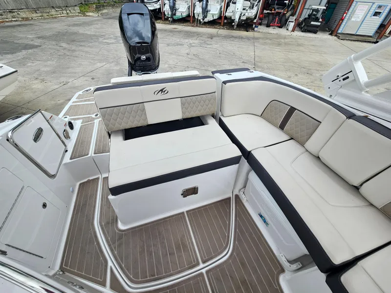 Slide: The Image of 2023 Monterey M-65 boat interior with cushioned seating and sleek design. - 9