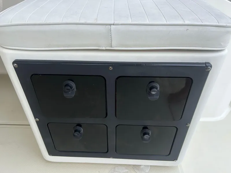 Slide: The Image of 1998 Carolina Classic 25 Express boat storage compartment with cushioned seat. - 10