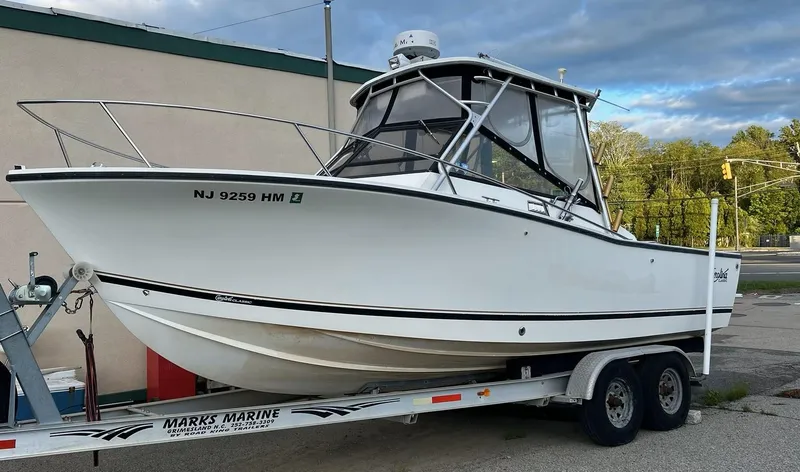 The Image of 1998 Carolina Classic 25 Express boat on trailer, parked outdoors. - 2