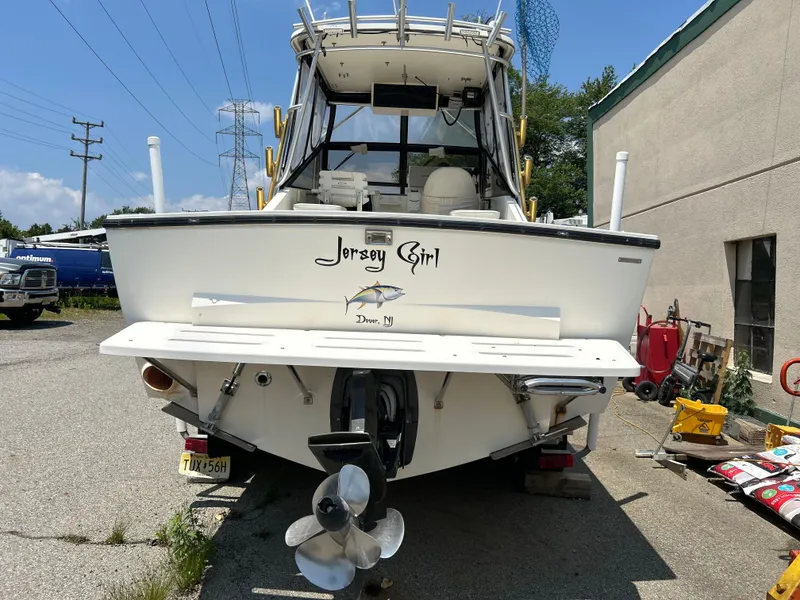 Slide: The Image of 1998 Carolina Classic 25 Express boat named "Jersey Girl" parked outdoors. - 8