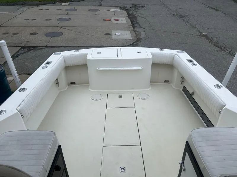 Slide: The Image of 1998 Carolina Classic 25 Express boat deck with seating and storage compartments. - 9
