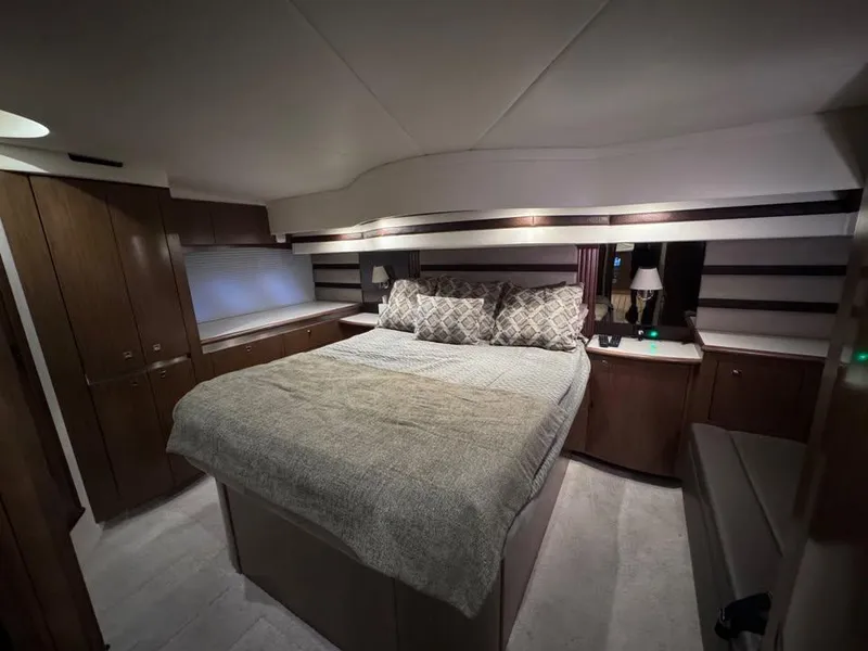 Slide: The Image of Luxurious bedroom interior of 2014 Cruisers Yachts 540 SC with elegant bedding and wood cabinetry. - 10