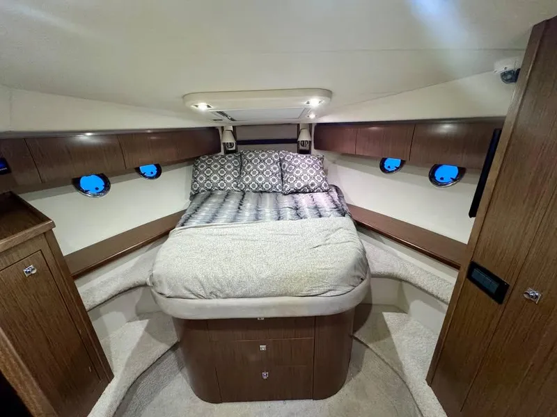 Slide: The Image of Luxurious cabin interior of 2014 Cruisers Yachts 540 SC with cozy bed and elegant wood finish. - 12
