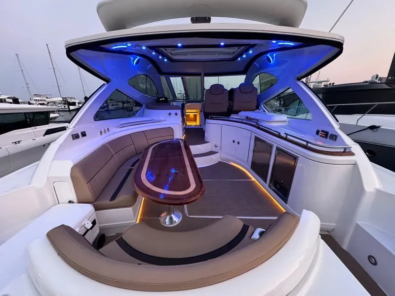 Slide: The Image of Luxurious 2014 Cruisers Yachts 540 SC interior with ambient blue lighting and elegant seating. - 13