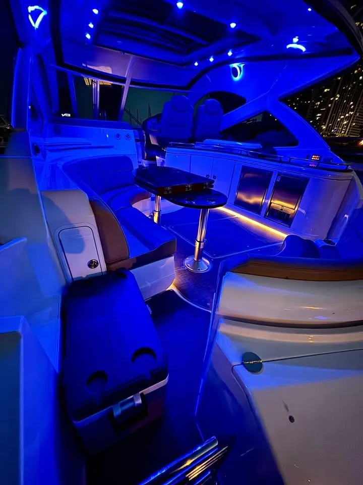 Slide: The Image of 2014 Cruisers Yachts 540 SC interior with blue LED lighting and luxurious seating. - 15