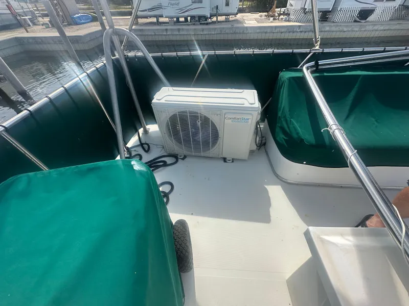Slide: The Image of 1989 Bluewater 51' Coastal Cruiser deck with green covers and air conditioning unit. - 13