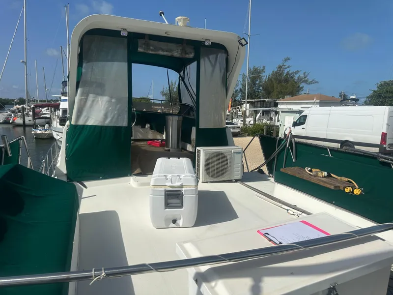 Slide: The Image of 1989 Bluewater 51' Coastal Cruiser docked, featuring green canopy and deck accessories. - 15