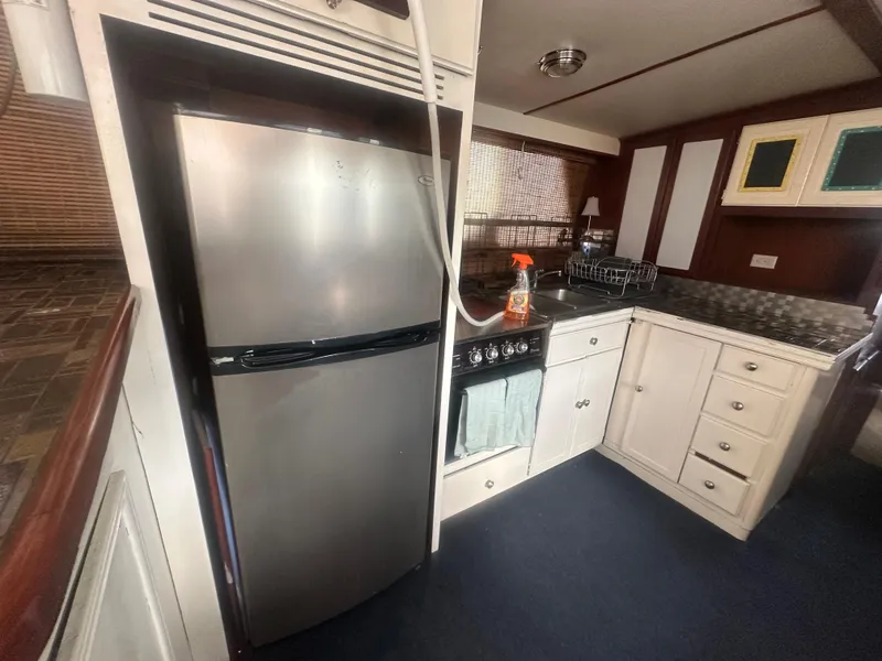 Slide: The Image of 1989 Bluewater 51' Coastal Cruiser kitchen with stainless steel appliances and white cabinetry. - 17