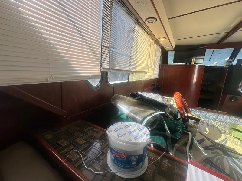 Slide: The Image of Interior of 1989 Bluewater 51' Coastal Cruiser with blinds, table, and various items. - 20
