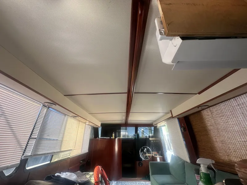 Slide: The Image of Interior of 1989 Bluewater 51' Coastal Cruiser with helm, seating, and window blinds. - 22