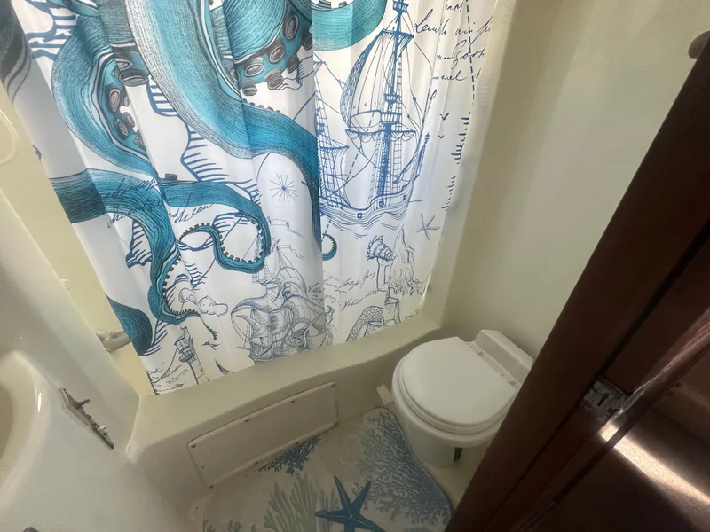 Slide: The Image of Bathroom in 1989 Bluewater 51' Coastal Cruiser with nautical-themed shower curtain. - 24