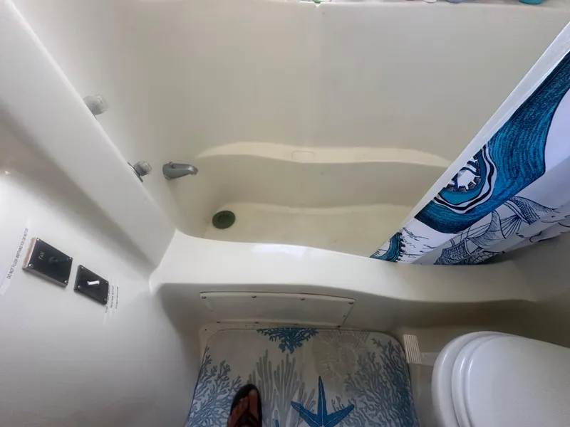 Slide: The Image of Bathroom interior of 1989 Bluewater 51' Coastal Cruiser with tub and nautical-themed shower curtain. - 25