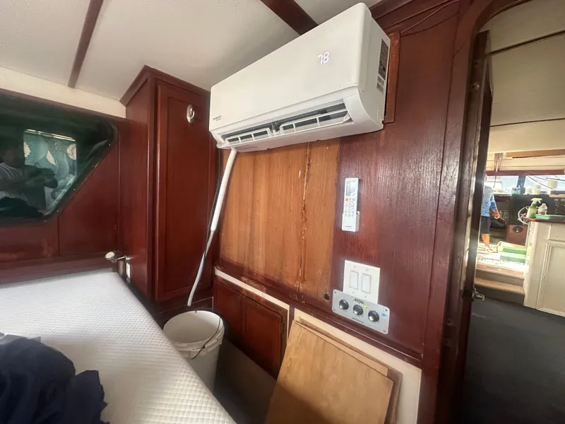 Slide: The Image of 1989 Bluewater 51' Coastal Cruiser interior with wood paneling and air conditioning unit. - 27