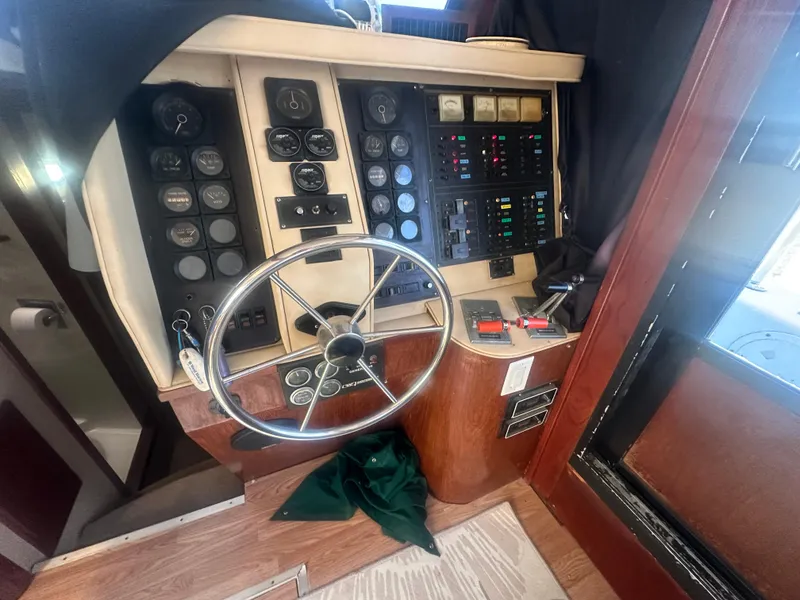 Slide: The Image of 1989 Bluewater 51' Coastal Cruiser helm with steering wheel and control panels. - 28