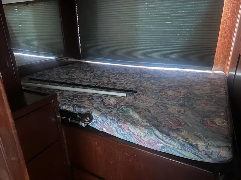 Slide: The Image of 1989 Bluewater 51' Coastal Cruiser interior with floral mattress and wooden furnishings. - 32