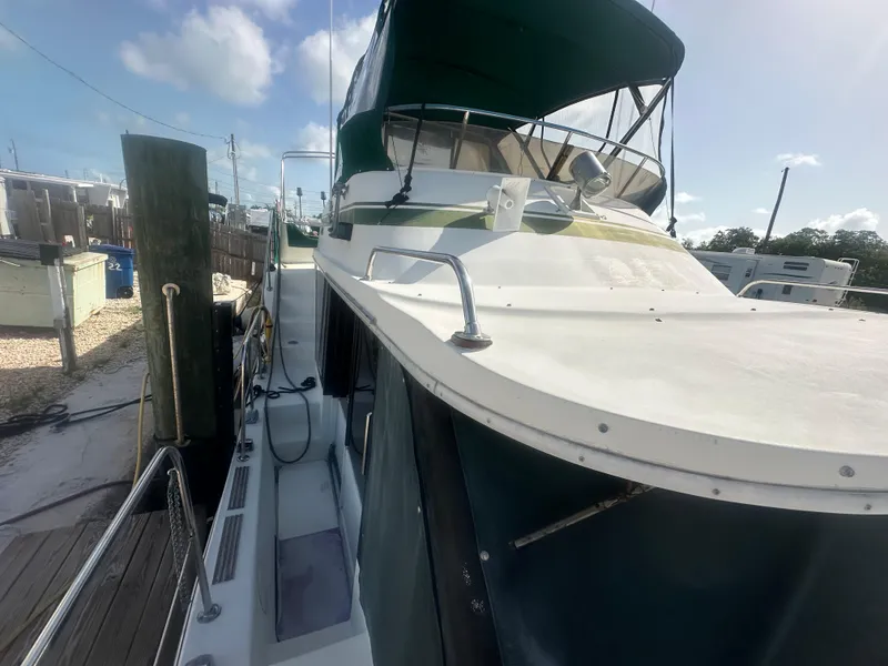 Slide: The Image of 1989 Bluewater 51' Coastal Cruiser docked, showcasing deck and cabin under a clear sky. - 7