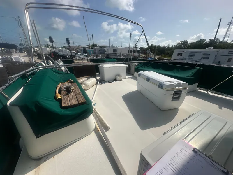 Slide: The Image of 1989 Bluewater 51' Coastal Cruiser deck with green covers and storage boxes. - 8