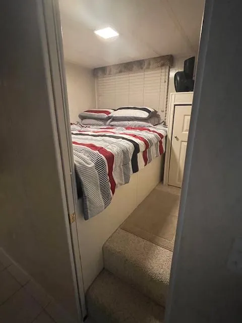 Slide: The Image of Cozy bedroom in 2000 Funtime 16x72 houseboat with striped bedding and carpeted steps. - 11