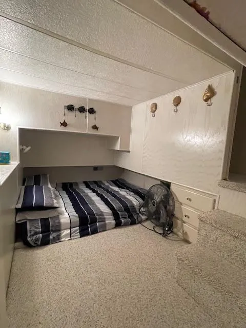 Slide: The Image of Cozy bedroom in 2000 Funtime 16x72 houseboat with striped bedding and wall decor. - 12