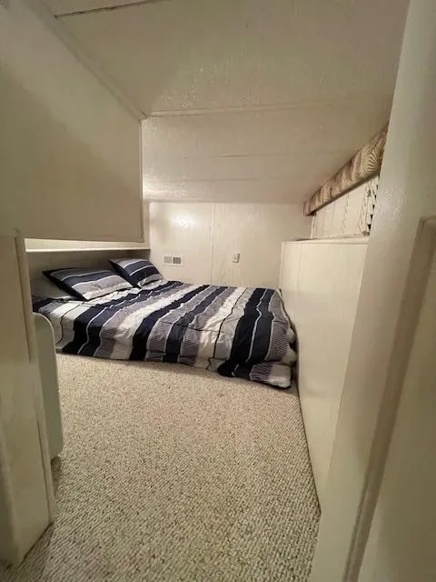 Slide: The Image of Cozy bedroom in 2000 Funtime 16x72 houseboat with striped bedding. - 13